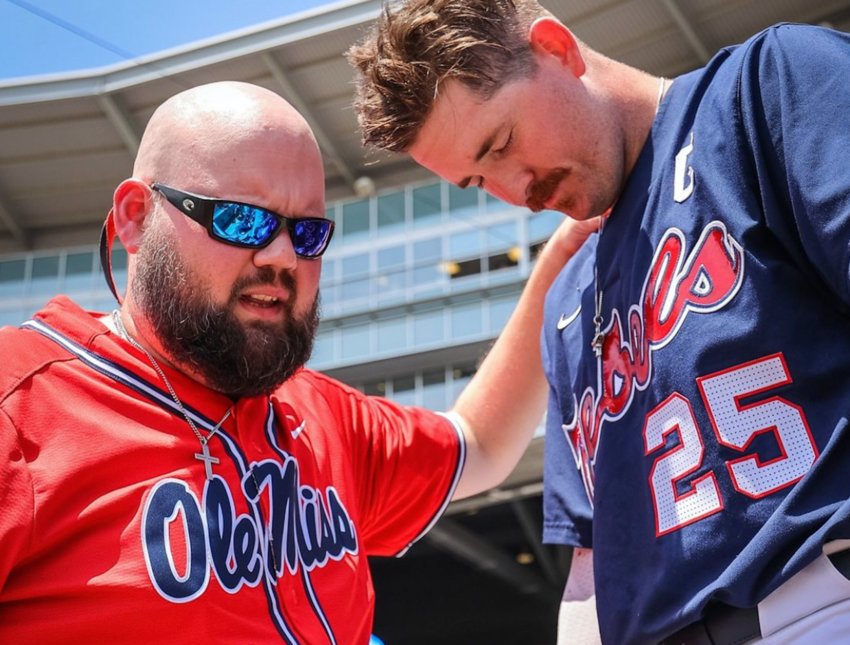 This moment between Sebastopol’s Tyler Comans, left, and Ole Miss team captain Tim Elko praying before Game 1 of the College World Series on Saturday was captured by the NCAA and went viral on Instagram.